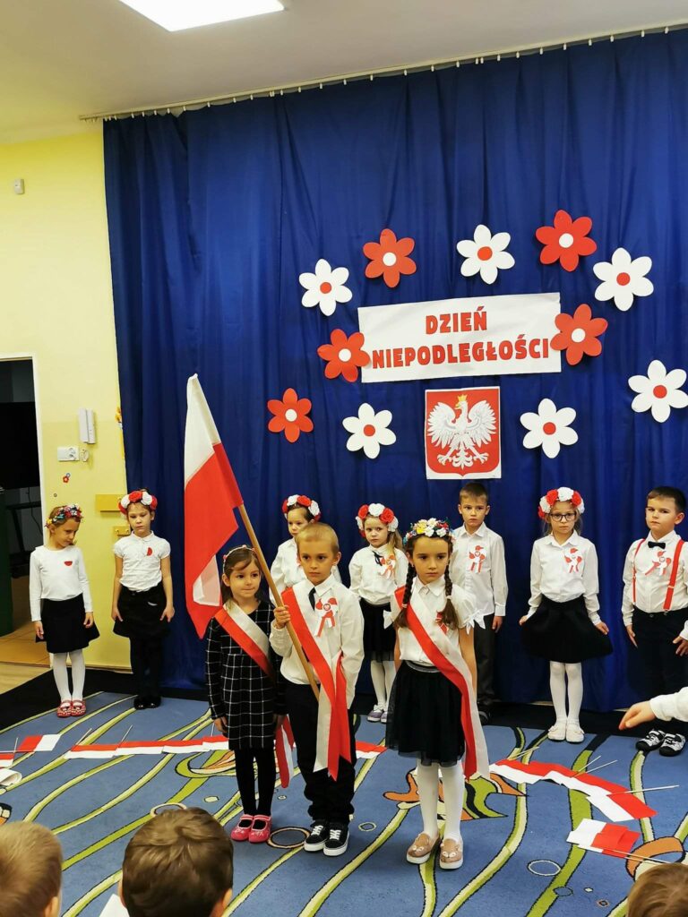 Dzieci z grupy Biedronek stoją ze sztandarem.
