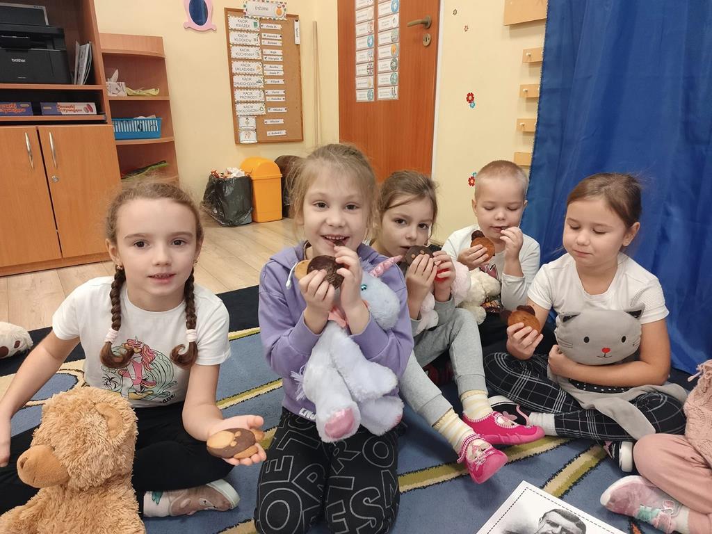Dzieci jedzą ciastka w kształcie misia.