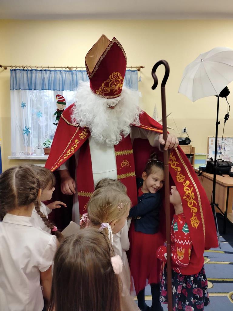 Dzieci przytulają św. Mikołaja.