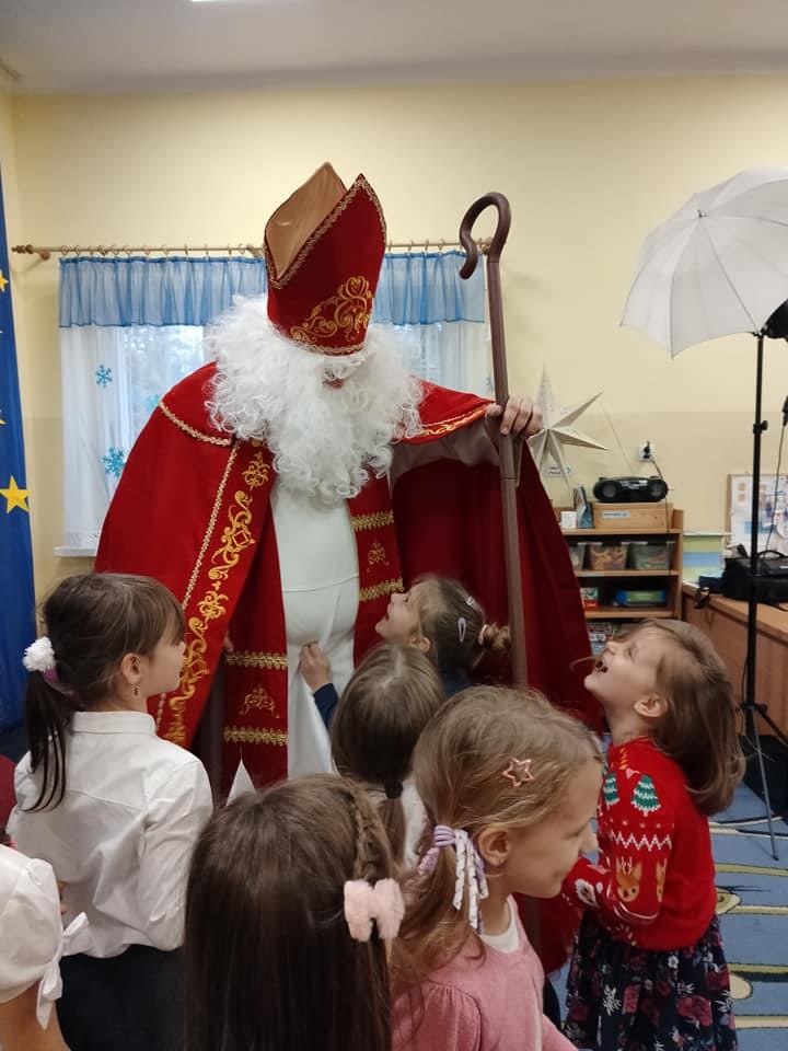 Dzieci przytulają św. Mikołaja.